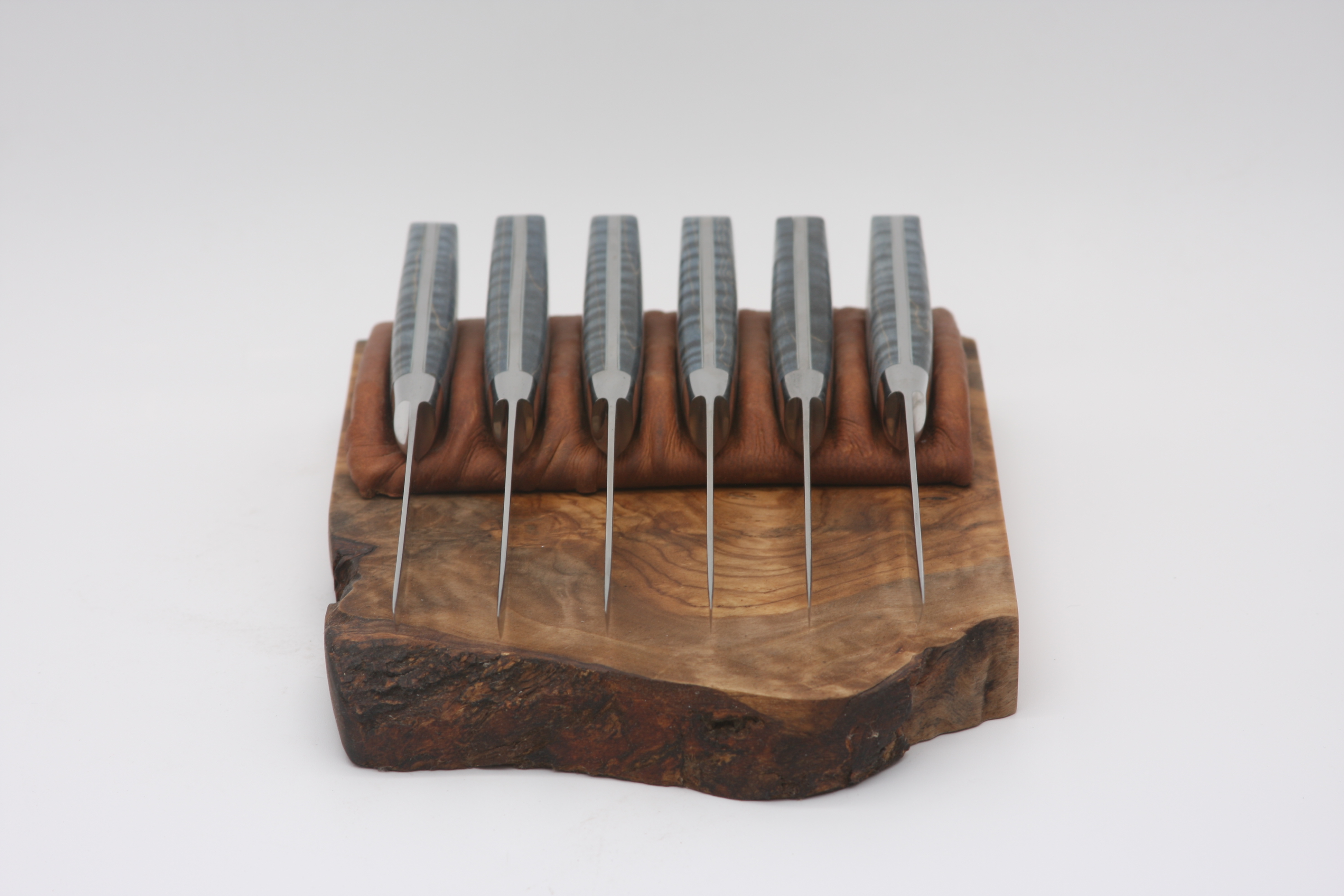 Blue Curly Maple Steak Set on an olive wood base with leather-wrapped holders